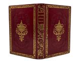 a red book with gold trimming and ornate design on the cover