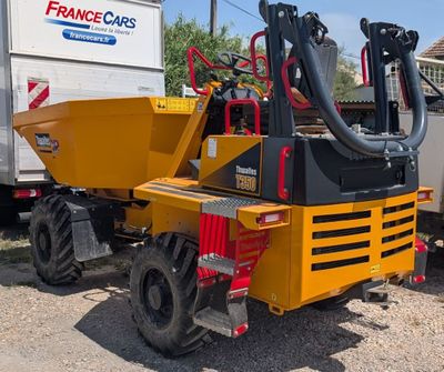 a yellow truck with a machine attached to it ' s back