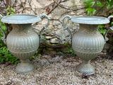 two vases sitting next to each other on the ground