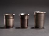 three shot glasses sitting next to each other on top of a table