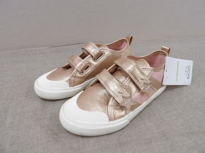 the children ' s shoes are gold and white with a white sole