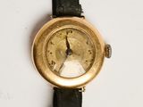 a gold wrist watch on a black strap