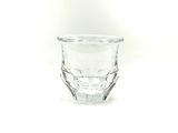 a small glass cup sitting on a white surface