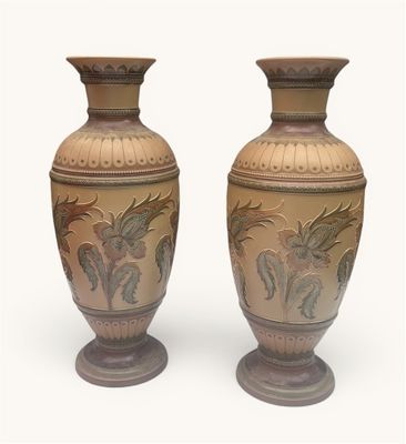 two vases sitting side by side on a white surface