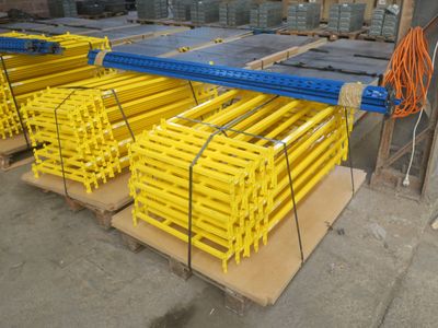 Plusieurs palettes d'acier sont empilées les unes sur les autres dans un entrepôt.