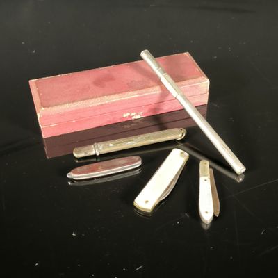 un couteau, un stylo et une boîte posés sur une table