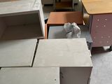 plusieurs bureaux et armoires dans une pièce, avec un chat assis sur l'un d'entre eux