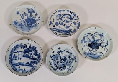 quatre assiettes ornées de motifs bleus et blancs sur un fond blanc