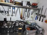 de nombreuses casseroles et poêles accrochées au mur de la cuisine