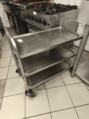 une cuisine avec une cuisinière et un chariot au milieu de la pièce