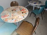 a table and chairs in a room that has a lot of pictures on the table