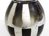 un vase noir et blanc posé sur une surface blanche