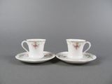 a pair of cups and saucers with floral designs on them
