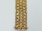 a close up of a gold bracelet on a white surface
