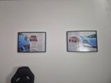 two pictures hanging on the wall of a car showroom
