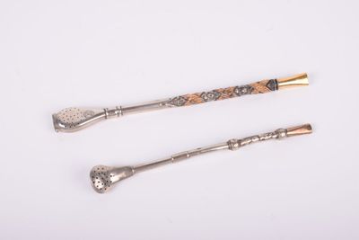 two silver spoons and a spoon with a handle on a white surface