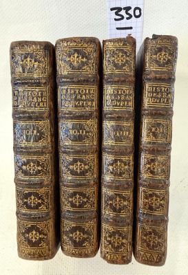 five old books are stacked on top of each other on a table