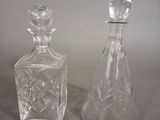 two glass bottles sitting next to each other on a table