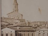 an old photo of a town with a clock tower in the background