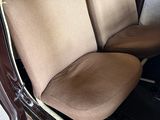 the interior of an old car with two seats and a steering wheel