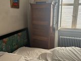 a bed with a white sheet on it in a bedroom