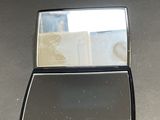 a compact mirror sitting on a table next to a cell phone
