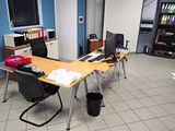 une pièce avec un bureau, des chaises et une bibliothèque