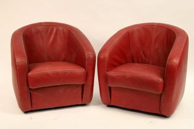 pair of red leather swivel chairs on a white background