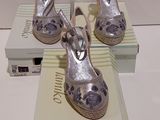 trois paires de chaussures argentées posées sur des boîtes, sur une table