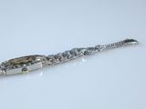 a close up of a silver bracelet on a white surface