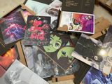 a pile of postcards sitting on the floor next to a pile of books