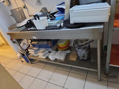 une photo d'une cuisine en désordre avec un micro-ondes posé sur le plan de travail