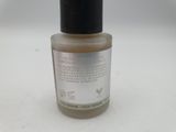 a close up of a bottle of liquid on a white surface