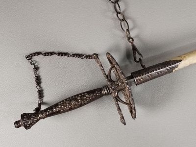 a knife hanging from a chain on the wall