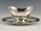 une assiette en argent avec une soucoupe posée dessus