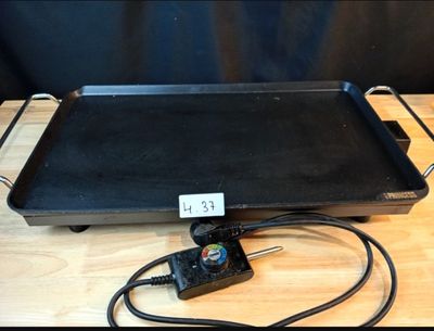 a black grill on a wooden table with a clock on it