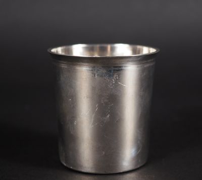 un gros plan d'une tasse en métal posée sur une surface noire