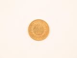 une image d'une pièce d'or sur une surface blanche