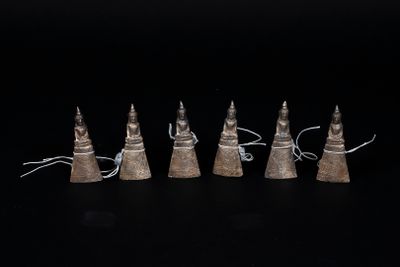 five metal cones with a string attached to them on a black surface