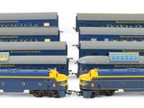 four blue and yellow train cars sitting next to each other
