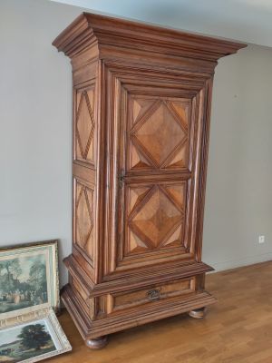 a tall wooden cabinet in the corner of a room