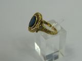 a close up of a gold ring with a blue stone in it