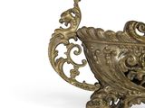 a gold vase that is sitting on a white surface