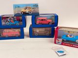 four toy cars that are sitting in boxes on a table