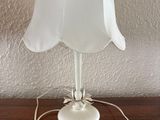 a white lamp that is on a wooden table