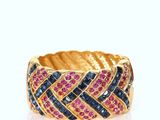 a close up of a gold ring with blue and pink stones