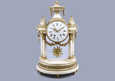 une horloge blanche et or posée sur une table
