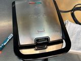 un grille-pain posé sur une table, à côté d'une serviette et d'un stylo