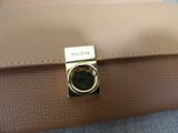 brown leather purse with a gold buckle on top of it