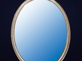 an ornate silver framed mirror against a dark blue background